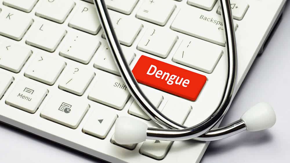 Estetoscópio sobre teclado com uma tecla vermelha escrito dengue.