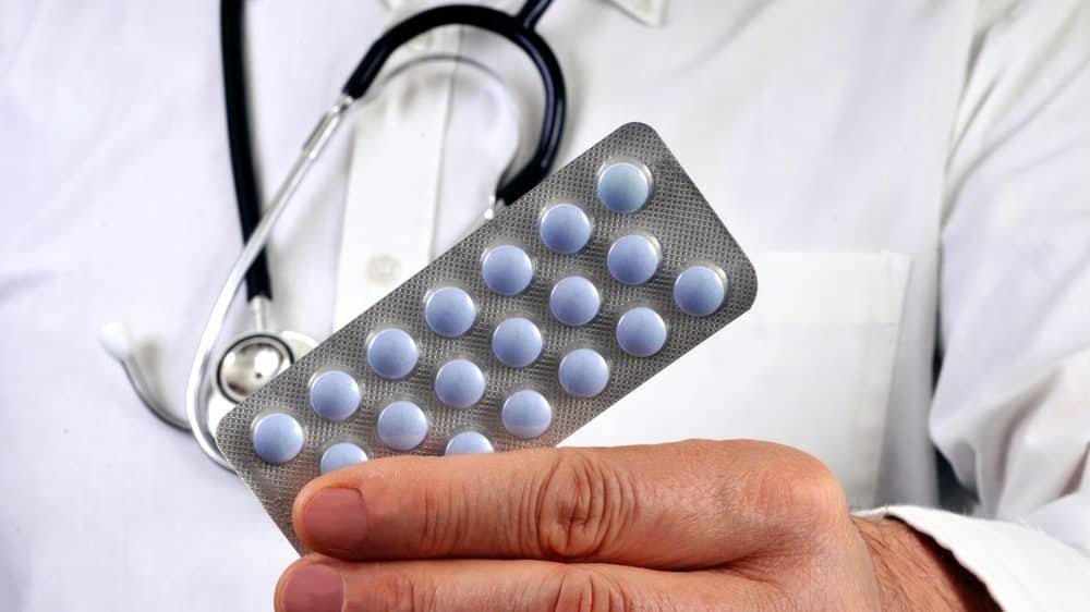 close de mão de médico segurando cartela de medicamentos. remédios para dormir têm efeitos colaterais que podem ser perigosos