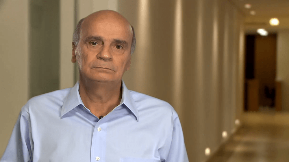 Drauzio Varella em um corredor olhando para a câmera