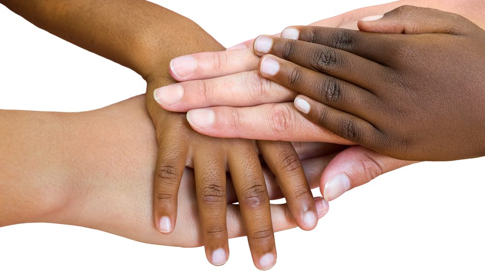 close de mãos de crianças de raça diferente juntas.