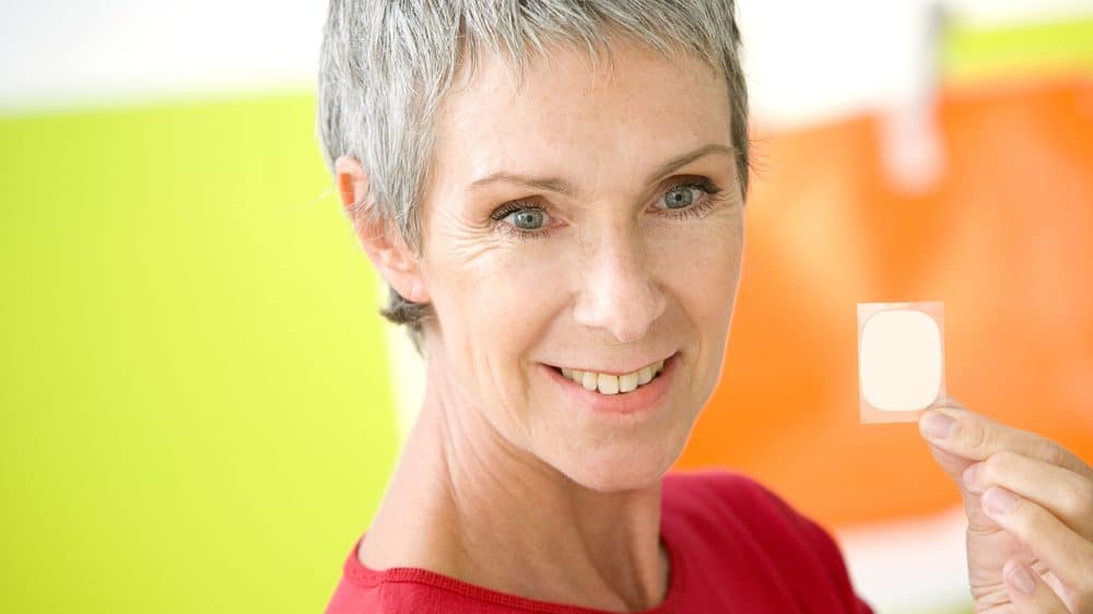 mulher na menopausa segura patch de reposição hormonal