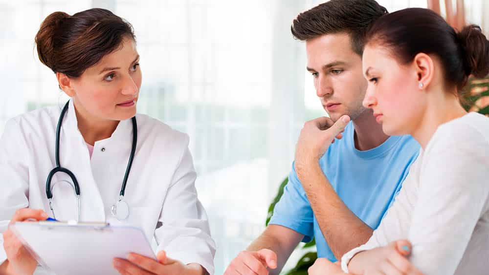 Médica orientando casal.