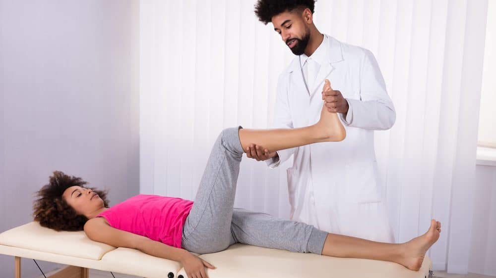 mulher deitada fazendo exercício de fisioterapia