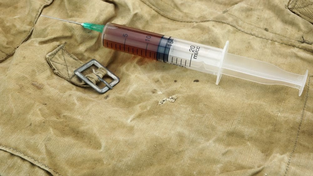 DNA de Bin Laden | Artigo seringa com líquido marrom sobre bolsa militar. ética médica deve ser respeitada até em guerras