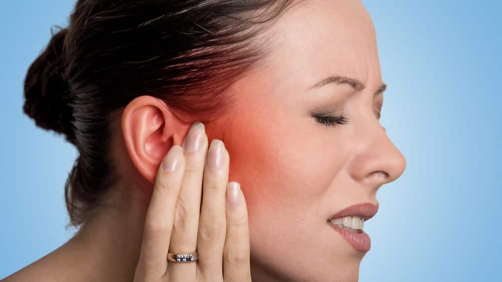 Neuralgia do trigêmeo | Entrevista mulher com mão no lado da face, em sinal de dor. neuralgia do trigêmeo atinge um dos lados da face