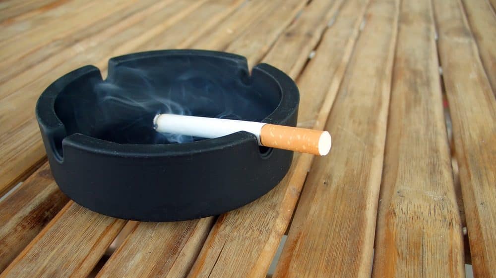cigarro queimando em cinzeiro. dependência do cigarro é pior que de outras drogas