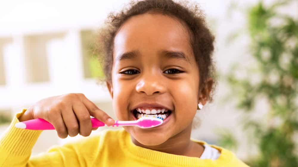 menina pequena escova os dentes. evolução dos dentes foi enorme nos últimos séculos