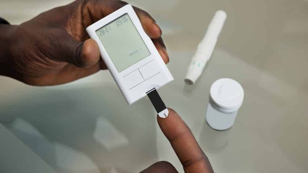 close de mão de paciente realizando exame para checar o nível de glicose no sangue