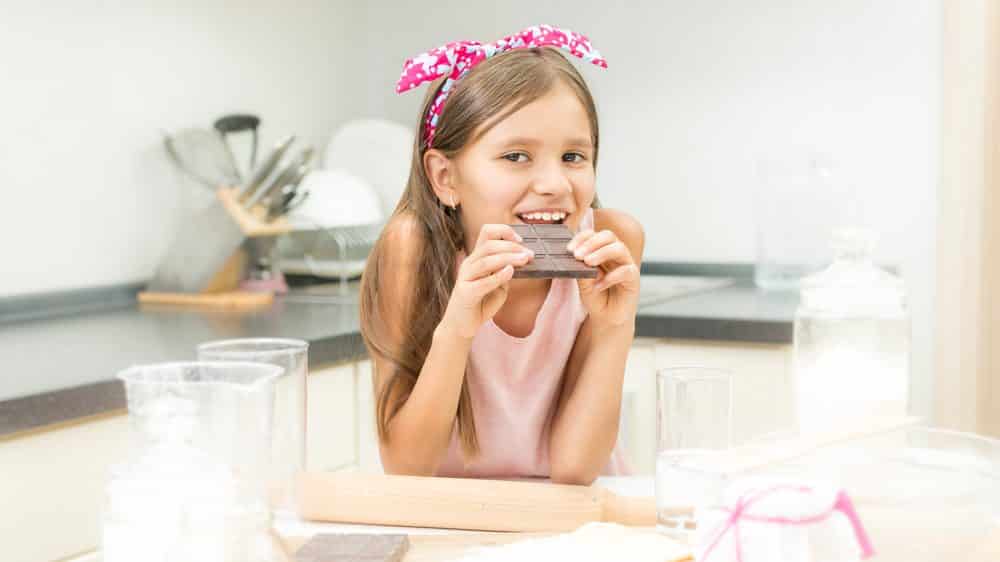 menina com dificuldade para engordar come chocolate