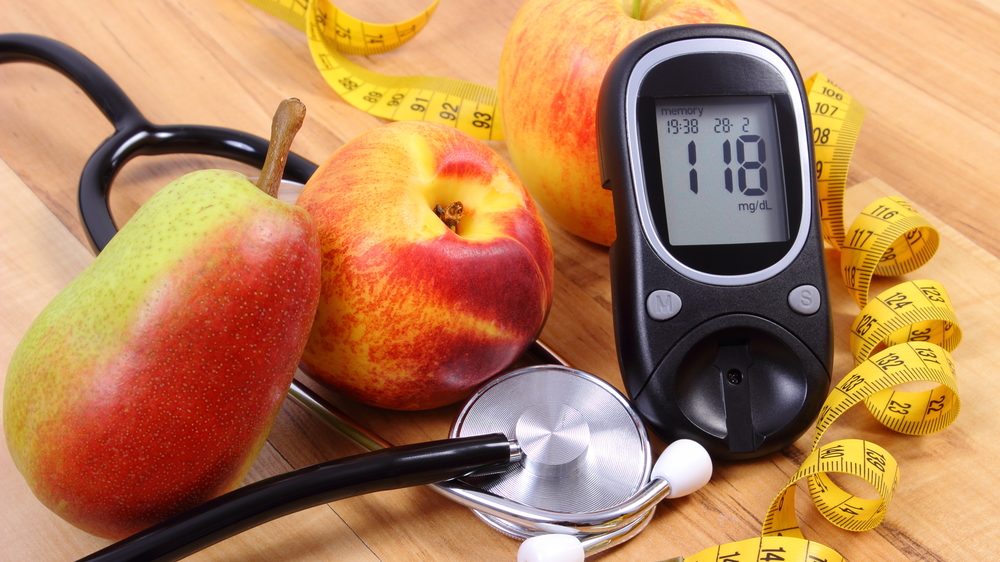 A história do diabetes | Artigo frutas, estetoscópio, fita métrica e aparelho de medir glicose para quem tem diabetes sobre uma mesa