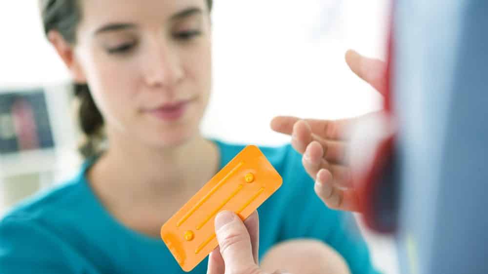 médico mostra cartela de pílula do dia seguinte para paciente