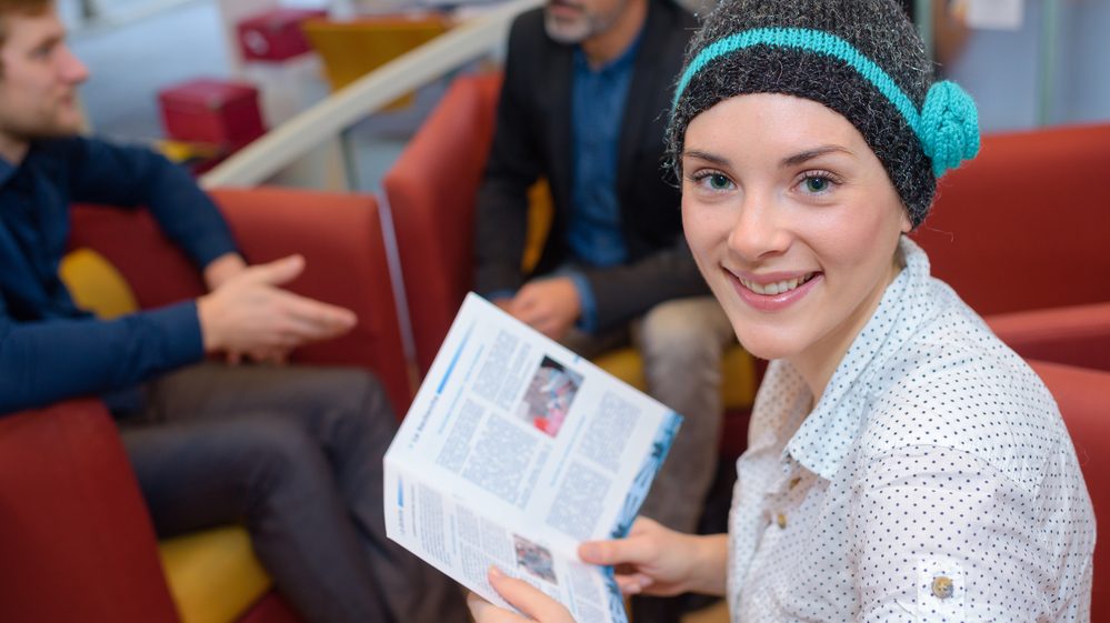 mulher com gorro lê livro. Pacientes com câncer sofrem mais no inverno
