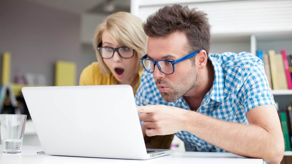 casal boquiaberto diante do computador. veja a lista do prêmio IgNobel