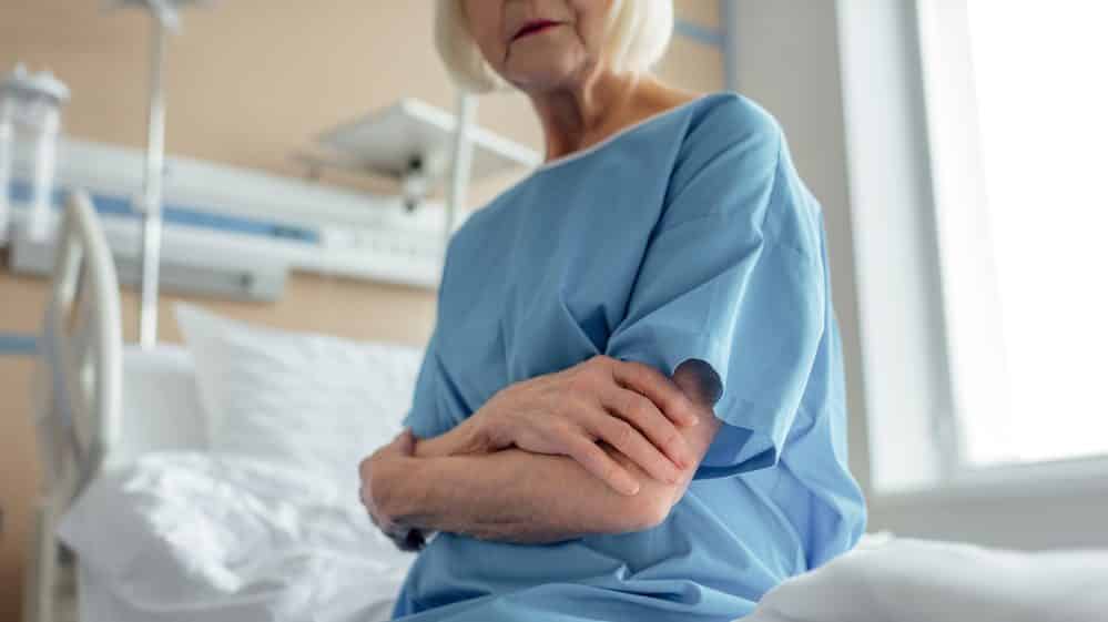 senhora sentada em cama de uti. delírios em uti são comuns