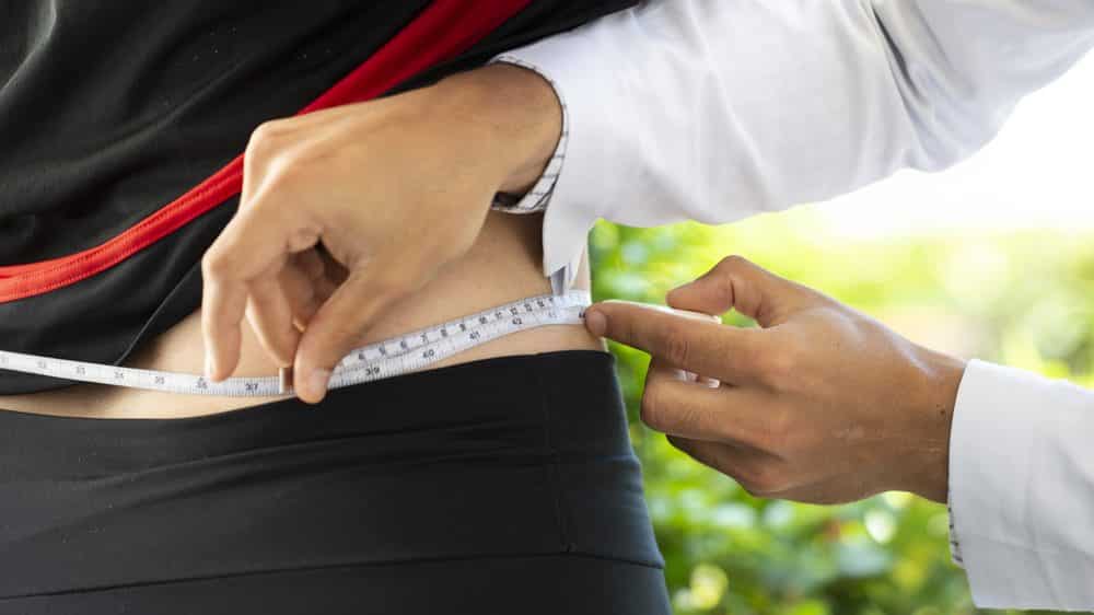 médico mede circunferência abdominal de mulher