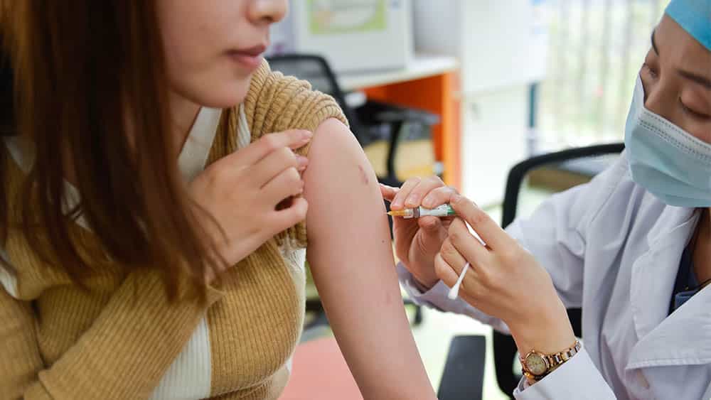 Mulher jovem recebendo vacina do HPV.
