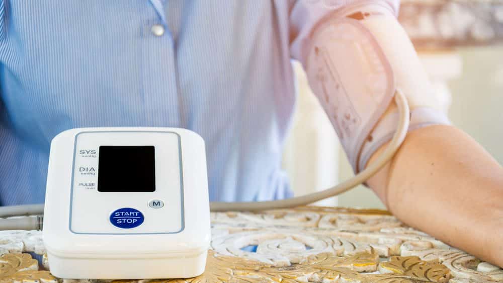 Reduzir a pressão diminui risco de complicações do diabetes mulher medindo a pressão em aparelho em casa