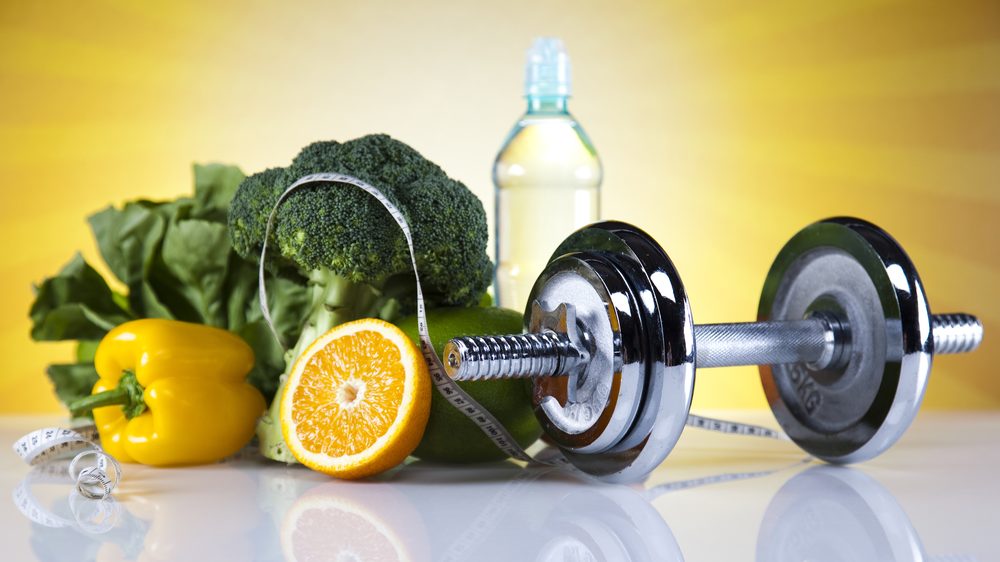 frutas, verduras, garrafa de água e peso para a prática de exercícios físicos, essenciais para o controle do diabetes