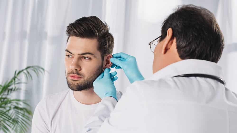 médico remove cerume de ouvido de paciente