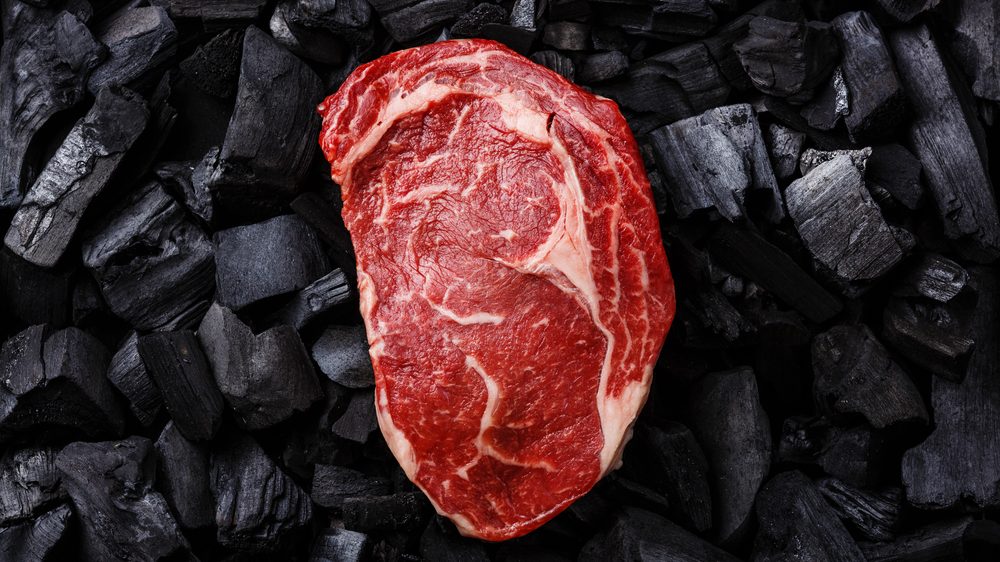 pedaço de carne crua sobre carvão. veja o papel da carne na alimentação