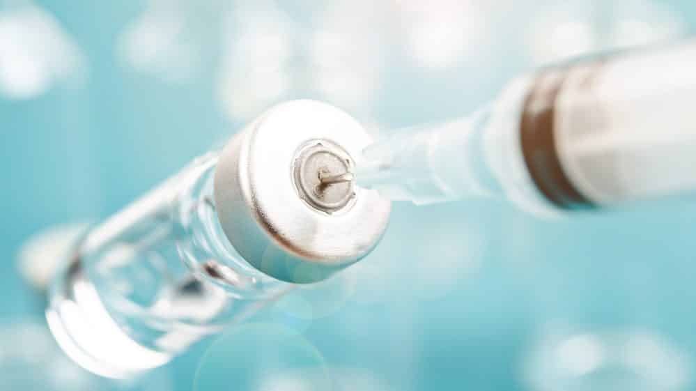 seringa retirando líquido de dentro de frasco de vacina. Vacinação contra o HPV é mais baixa que esperado