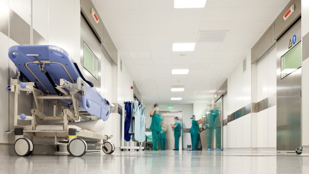 corredor de hospital com equipe médica atrás.demora no atendimento é uma espécie de eutanásia