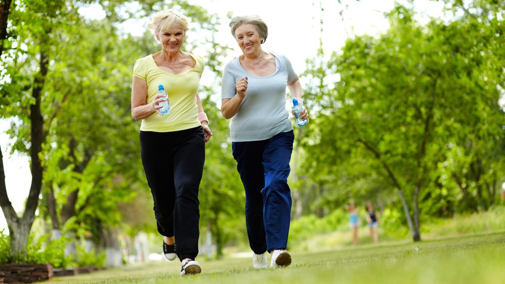 duas mulheres mais velhas praticam corrida; relação entre atividade física ajuda na prevenção ao câncer