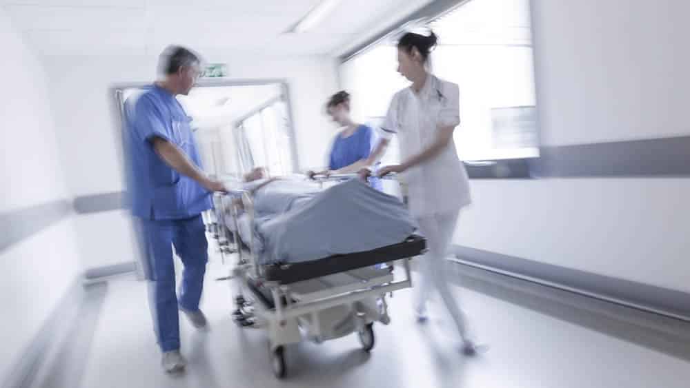 Paciente sendo levado na maca na emergência de hospital. SUS é o maior sistema público de saúde do mundo, mas tem gargalos