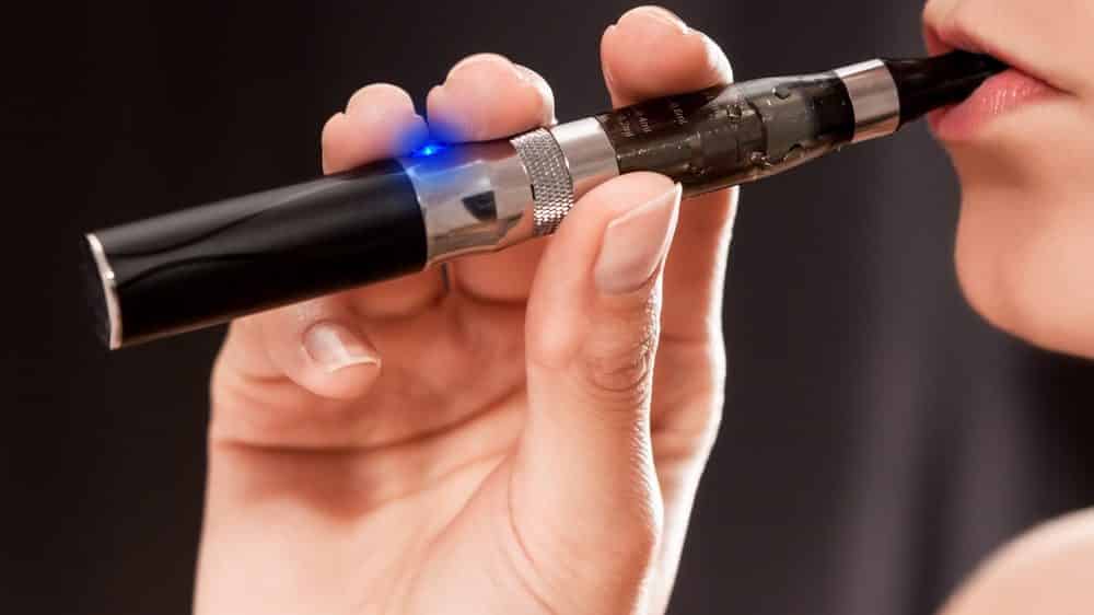 close no rosto de mulher fumando cigarro eletrônico