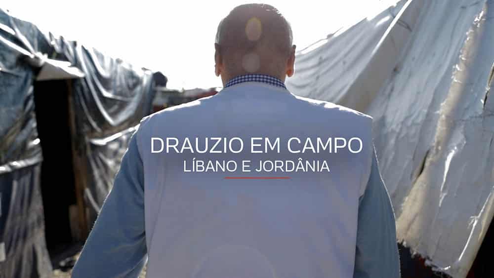 Drauzio em Campo | Teaser Drauzio de costas com colete de Médicos Sem Fronteiras andando em meio a tendas de refugiados no Líbano.