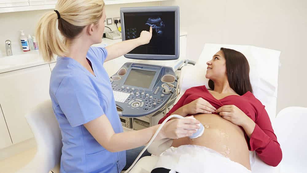 Mulher grávida fazendo ultrassom obstétrico.