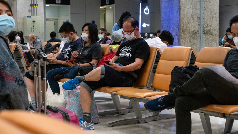 pessoas aguardam em aeroporto de Pequim usando máscaras para evitar a contaminação pelo Covid-19
