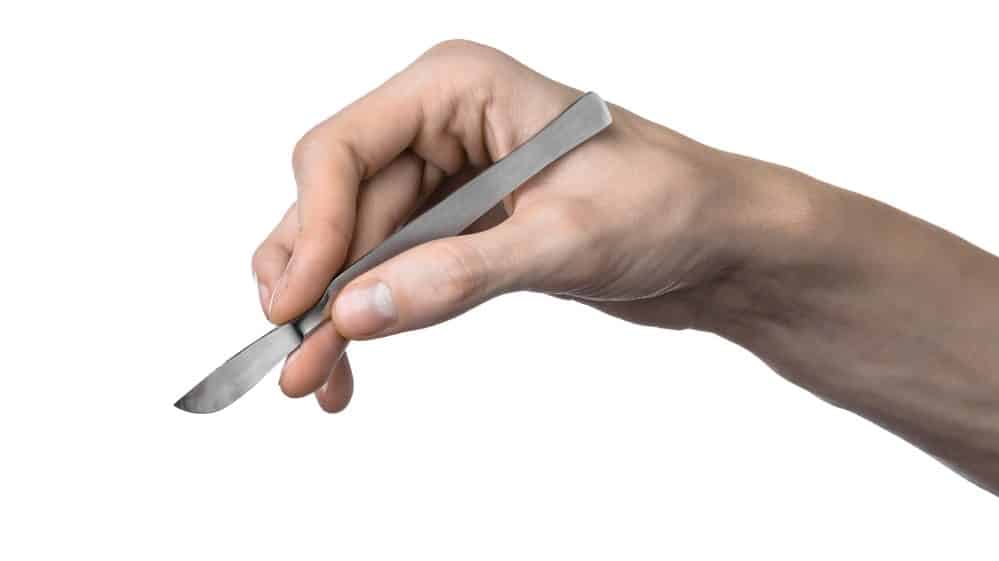 mão segurando bisturi. João de Deus fazia cirurgias sem ser médico
