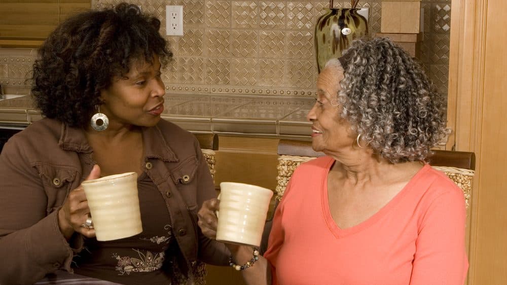 mulher adulta e mãe idosa tomam café. Idosos são mais vulneráveis ao coronavírus