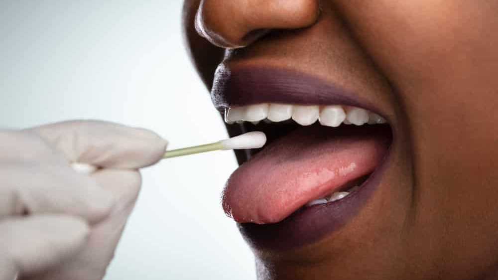 enfermeira colhe teste coronavírus na boca de paciente