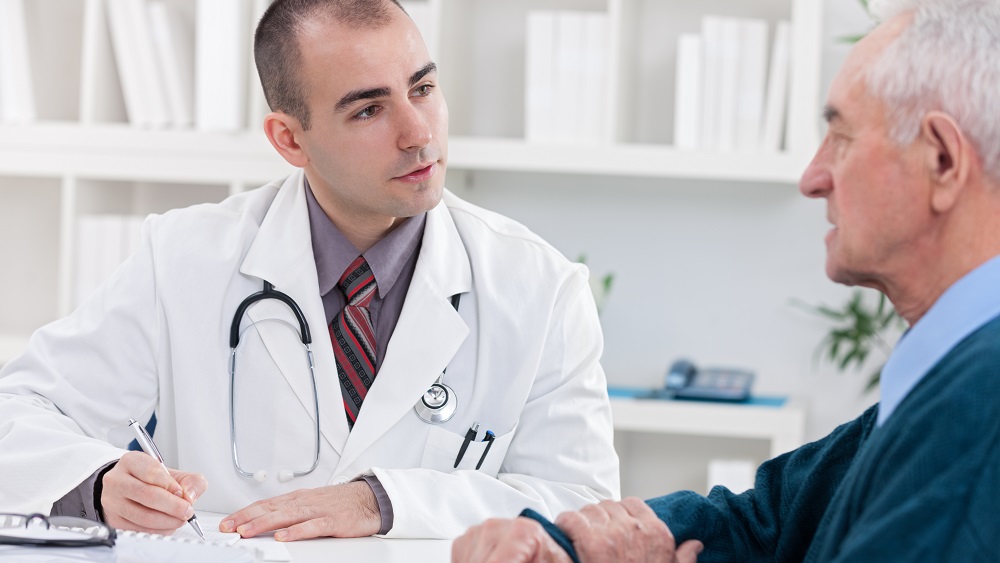 Médico conversa com paciente em consulta.
