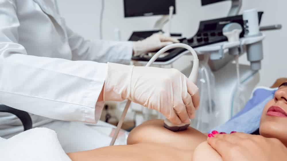 médico realiza ultrassom em paciente para verificar a presença de cistos mamários