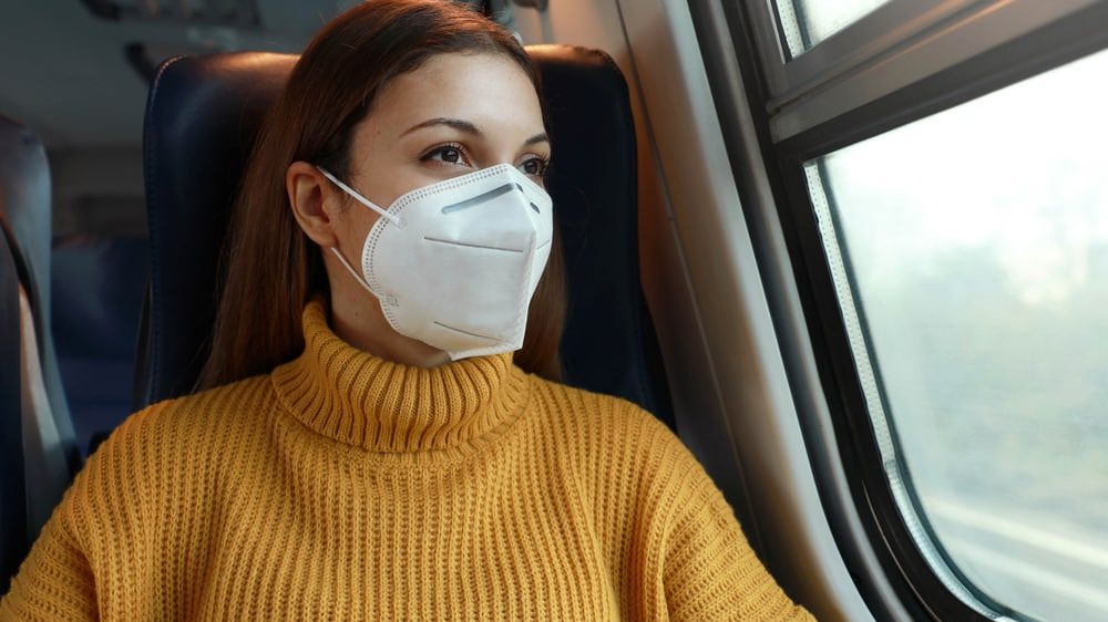 mulher de máscara viaja em transporte público. mutações do coronavírus preocupam