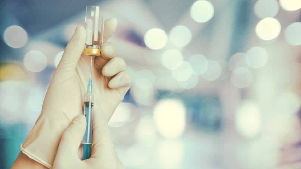 close em mão de enfermeira com seringa e vacina aprovada pela anvisa