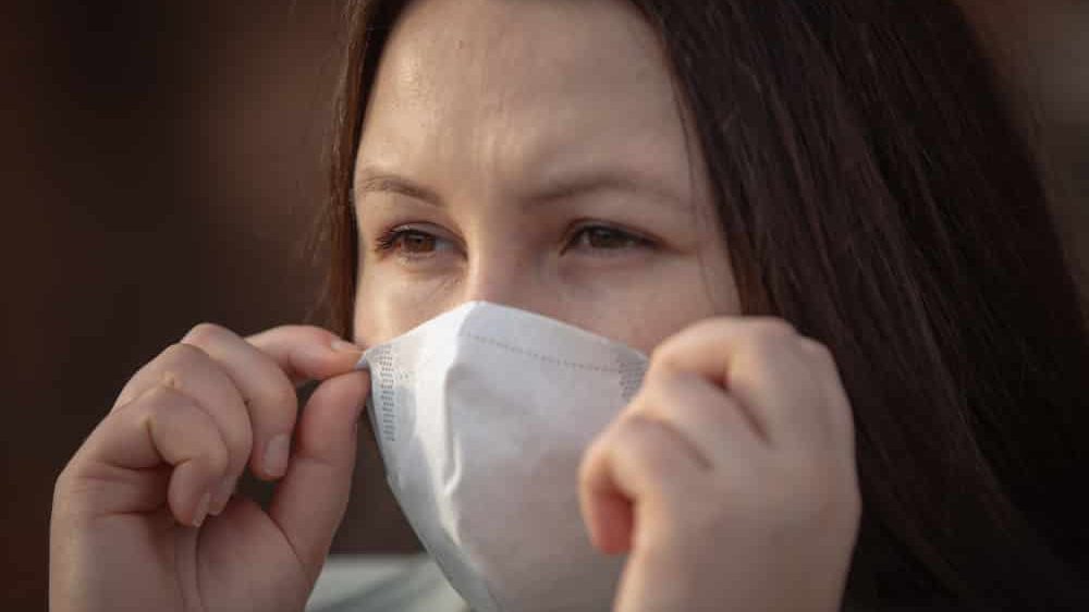 close em rosto de mulher com máscara. nova variante inglesa do coronavírus pode ser mais contagiosa