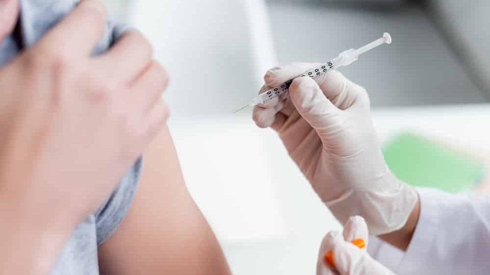 close em mão de enfermeira aplicando vacina no braço de paciente. Imunidade de rebanho pode não ser atingida com vacinação