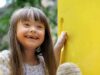 Menina com síndrome de Down brincando em playground.